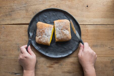 Cheese sandwich served on a plate, Female hands with cutlery.の写真素材