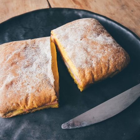 Cheese sandwiches toast served on black plate, on wooden table.の写真素材