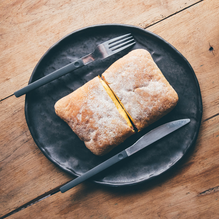 Cheese sandwiches toast served on black plate, on wooden table.の写真素材