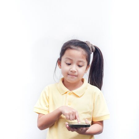 Cute little girl using smartphone. Kid hands hold smart phone.