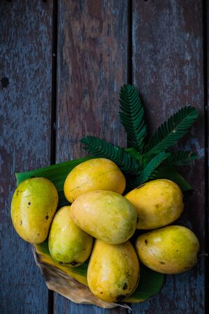 Yellow mango on wooden floor.の写真素材