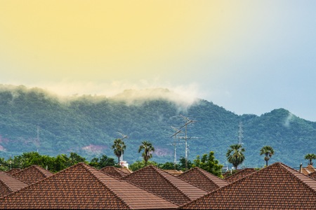 Fog on the mountain behind the houseの写真素材