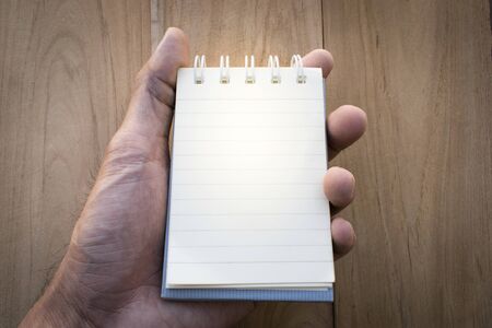 Hold white paper for notes on the background wood using wallpaper or background.