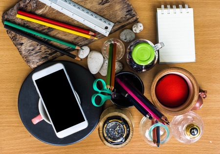 Paper for note, pencil, pen, coffee, clock and smartphone put on wooden board using wallpaper or background for business workの写真素材