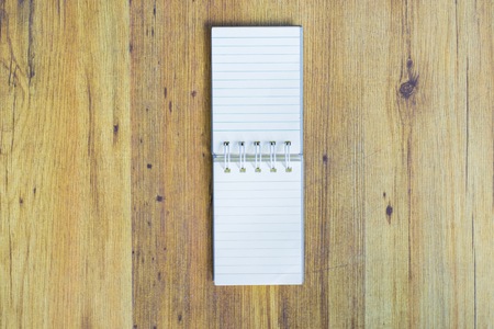 Notepad on wooden table. Using wallpaper or background for note and business work.の写真素材