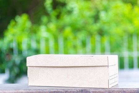 Carton on the wood and tree blurry bokeh background in garden. Using wallpaper for package work photo.の写真素材