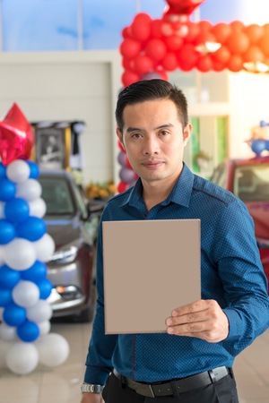 BANGSAN, THAILAND - July 23, 2017:   Asian man on background blurred car in showroom of Thailand's Mazda in Asia. He works customer care For finance, business with transportation and life insurance.の写真素材