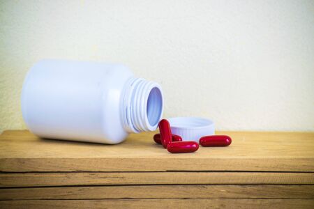 Bottle made to plastic on the wood with wall background. Using wallpaper for package or product and drug image.の写真素材