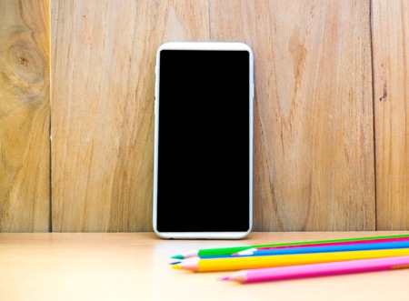 Smartphone with pencil on wood board background. using wallpaper or background for education, business photo. Take note of the product for book with paper and concept or copy space.の写真素材