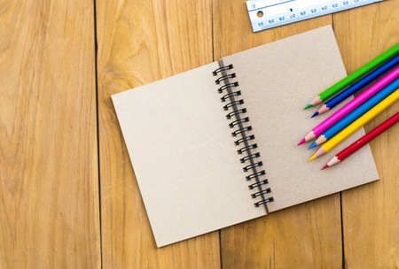 Notepad with pencil  on wood board background. using wallpaper or background for education, business...