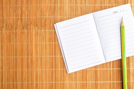 Notepad with pencil on wood board background. using wallpaper or background for education, business...