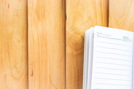 Notepad on wood background.using wallpaper for education, business photo. Take note of the product for book with paper concept or copy space and refreshing.の写真素材