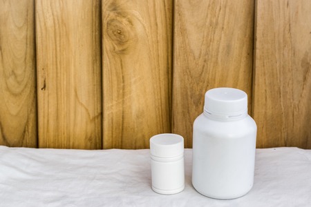 Bottle made to plastic on the wood background.Using wallpaper for package or product and drug image.の写真素材