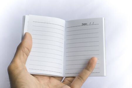 Man holding notepad with pencil on white background. using wallpaper or background for education, business photo. Take note of the product for book with paper concept or copy space and note.の写真素材