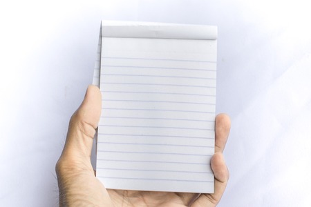 Man holding notepad with pencil on white background. using wallpaper or background for education, business photo. Take note of the product for book with paper concept or copy space and note.の写真素材