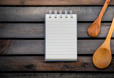 Notepad with spoons on wood board background. using wallpaper or background for education, business photo. Take note of the product for book with paper and concept or copy space and note.の写真素材