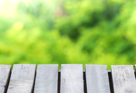 Empty wooden floor with tree blurred bokeh background. Using wallpaper or background for package...