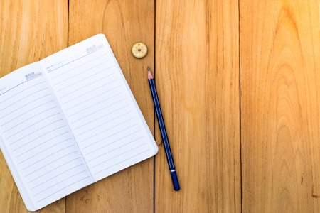 Notepad with pencil on wood board background. using wallpaper or background for education, business photo. Take note of the product for book with paper and concept or copy space and note.の写真素材