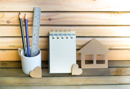 Notepad with pencil and home paper on wood board and tree blurry background. using wallpaper or background for education, business photo. Take note of the product for book with paper and concept or copy space and note.の写真素材