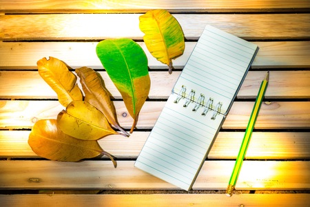 Notepad with pencil on wood board background. using wallpaper or background for education, business photo. Take note of the product for book with paper and concept or copy space and note.の写真素材