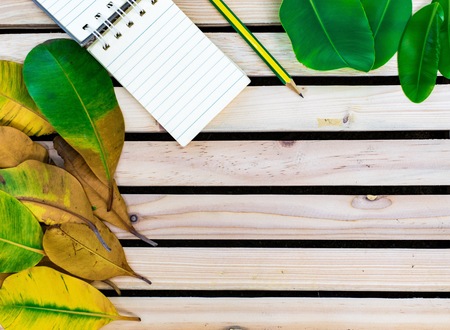 Notepad with pencil on wood board background. using wallpaper or background for education, business photo. Take note of the product for book with paper and concept or copy space and note.の写真素材