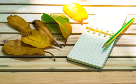 Notepad with pencil on wood board background. using wallpaper or background for education, business photo. Take note of the product for book with paper and concept or copy space and note.の写真素材