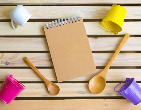 notepad with cup or glass and spoon on wood board background.using wallpaper or for education, business photo.Take note of the product for book with paper and concept or copy space and advertising.の写真素材