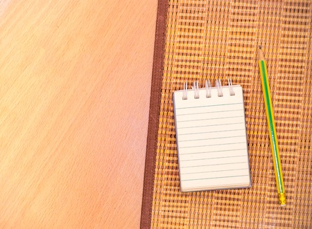 Notepad with pencil on wood board background.using wallpaper for education, business photo.Take note of the product for book with paper and concept or copy space.の写真素材