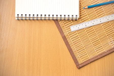 Notepad with pencil on wood board background.using wallpaper for education, business photo.Take note of the product for book with paper and concept or copy space.の写真素材
