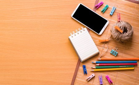Notepad with pencil and smart phone on wood board background.using wallpaper for education, business photo.Take note of the product for book with paper and concept or copy space.の写真素材
