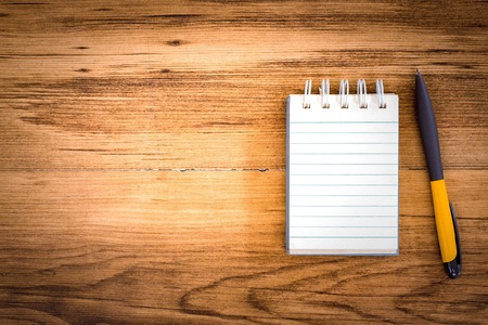 Notepad with pen on wood board background.using wallpaper for education, business photo.Take note of...