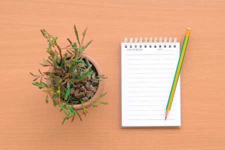 Notepad with pencil on wood board background.using wallpaper for education, business photo.Take note of the product for book with paper object, concept or copy space.の写真素材