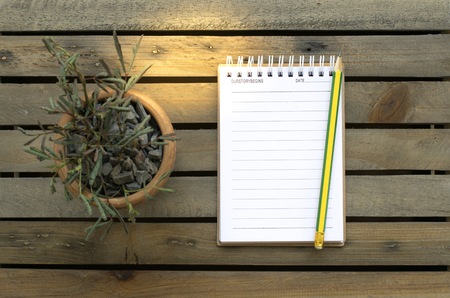 Notepad with pencil on wood board background.using wallpaper for education, business photo.Take note of the product for book with paper object, concept or copy space.の写真素材