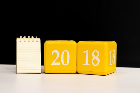 notepad with box number 2018 on wood background.using wallpaper for happy new year image.Take note of the product for book with paper and concept, object or copy space.の写真素材