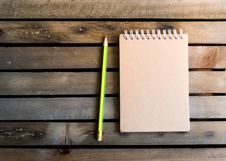 Notepad with pencil on wood board background.using wallpaper for education, business photo.Take note of the product for book with paper and concept, object or copy space.の写真素材