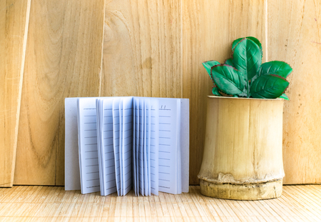 Notepad with tree in bamboo on wood board background.using wallpaper for education, business photo.Take note of the product for book with paper and concept, object or copy space.の写真素材
