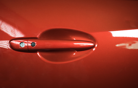 Car door handle red color for customers. Using wallpaper or background for transport and automotive image.の写真素材