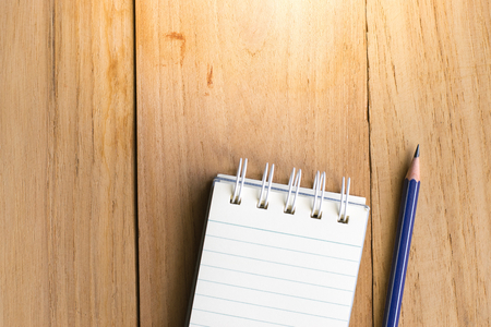 Notepad with pencil on wood board background.using wallpaper for education, business photo.Take note of the product for book with paper and concept, object or copy space.の写真素材