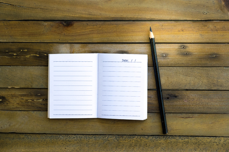 Notepad with pencil on wood board background.using wallpaper for education, business photo.Take note of the product for book with paper and concept, object or copy space.の写真素材