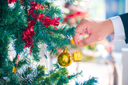 Man hand with christmas tree with leaf christmas and gift box on tree bokeh background. Using wallpaper or background for happy new year 2018 image.の写真素材