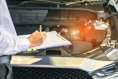 man writing on notepad or book, paper with car and blurry background. for note, transport, business, copy space image.の写真素材