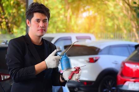 Asian men holding technical equipment in car service center and blurry background. for for transport and automotive image.の写真素材
