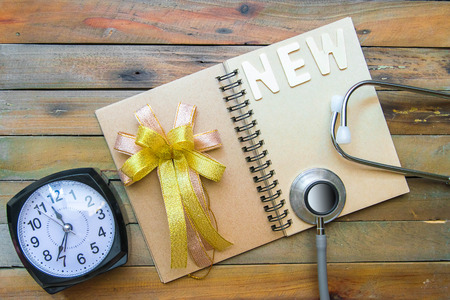 Notepad with stethoscope and pencil on wood board background.using wallpaper for education, business photo.Take note of the product for book with paper object, concept or copy space.の写真素材