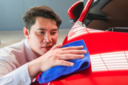 Man asia wipe car with led headlight for customers. Using wallpaper or background for transport and automotive image.の写真素材