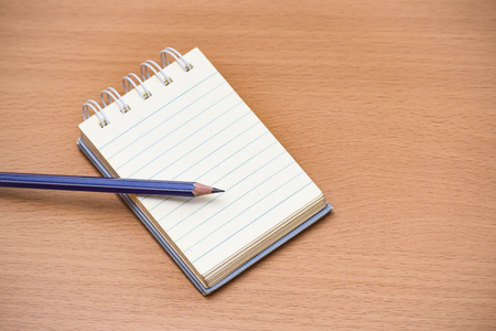Notepad with pencil on wood board background.using wallpaper for ...