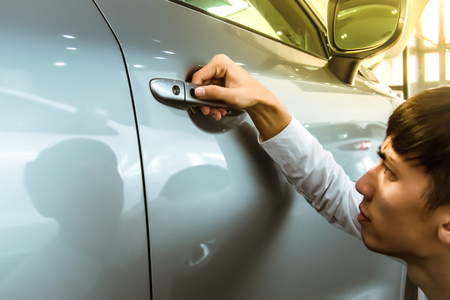 Asian man opens car door with smart keyless For automotive or transportation imageの写真素材
