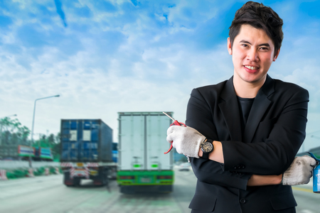 Asian men wearing suits with repair equipment on car street and traffic blurred background. For automotive or transportation imageの写真素材