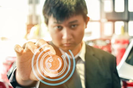 Asian man business holding tecnology bit coin in blurry office background. For business people, finance, lifestyle and ethereum or block chain tecnology imageの写真素材