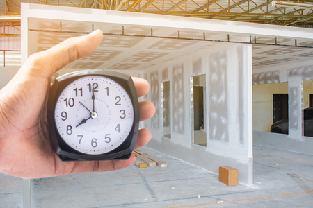Holding clock on industry blurred background The time 8:00 am or pm and noon or midnight for made clock isolated or White background Copy space move to clipping pathの写真素材