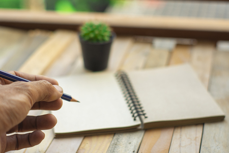 man business inspection writing Notepad with pencil on wood board background.using wallpaper for education, business photo.Take note 
of the product for book with paper and concept, object or copy space.の写真素材